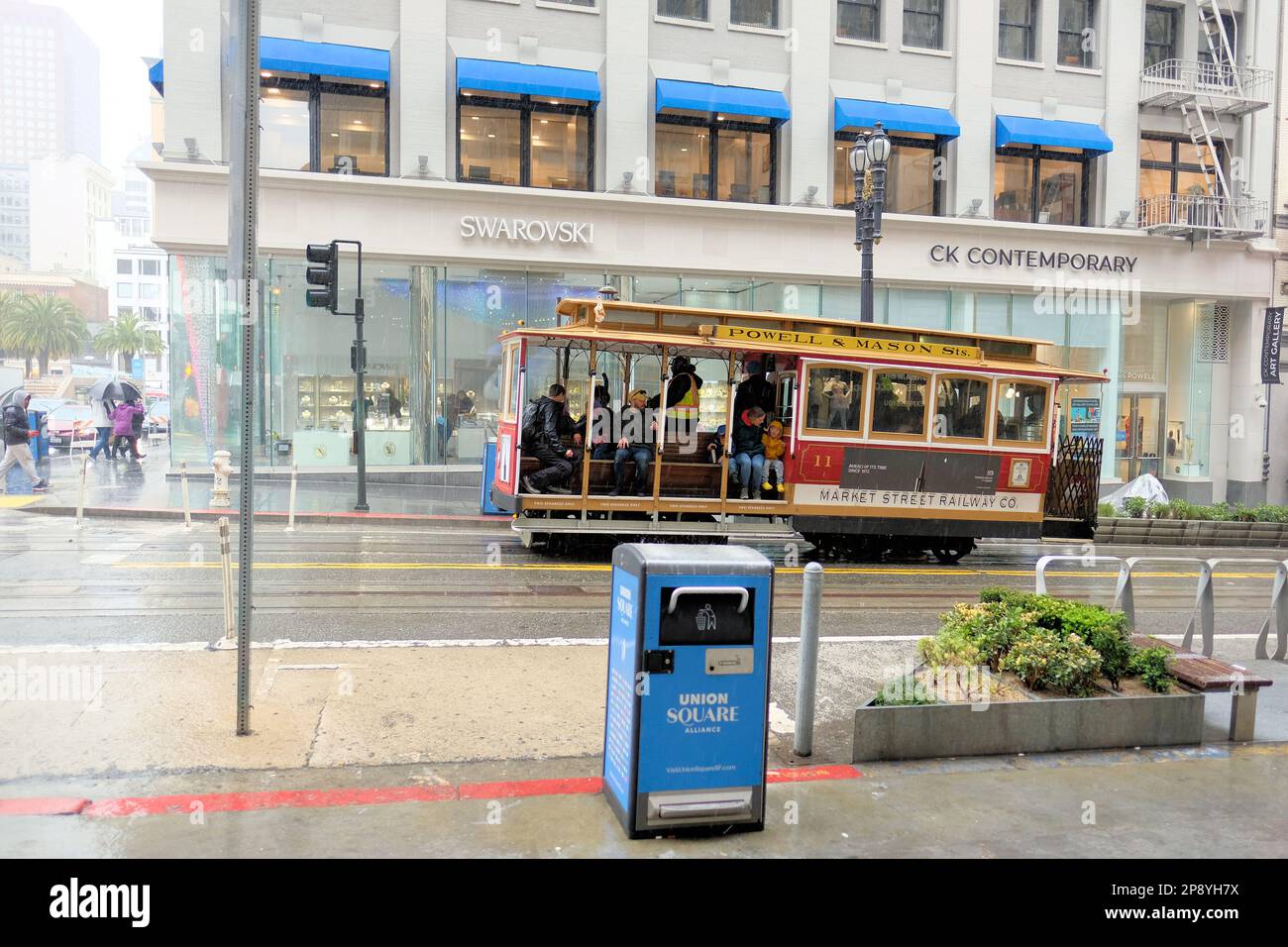 Turisti e visitatori su un tram sotto la pioggia nel centro di San Francisco, California; persone in condizioni di pioggia e clima umido. Foto Stock