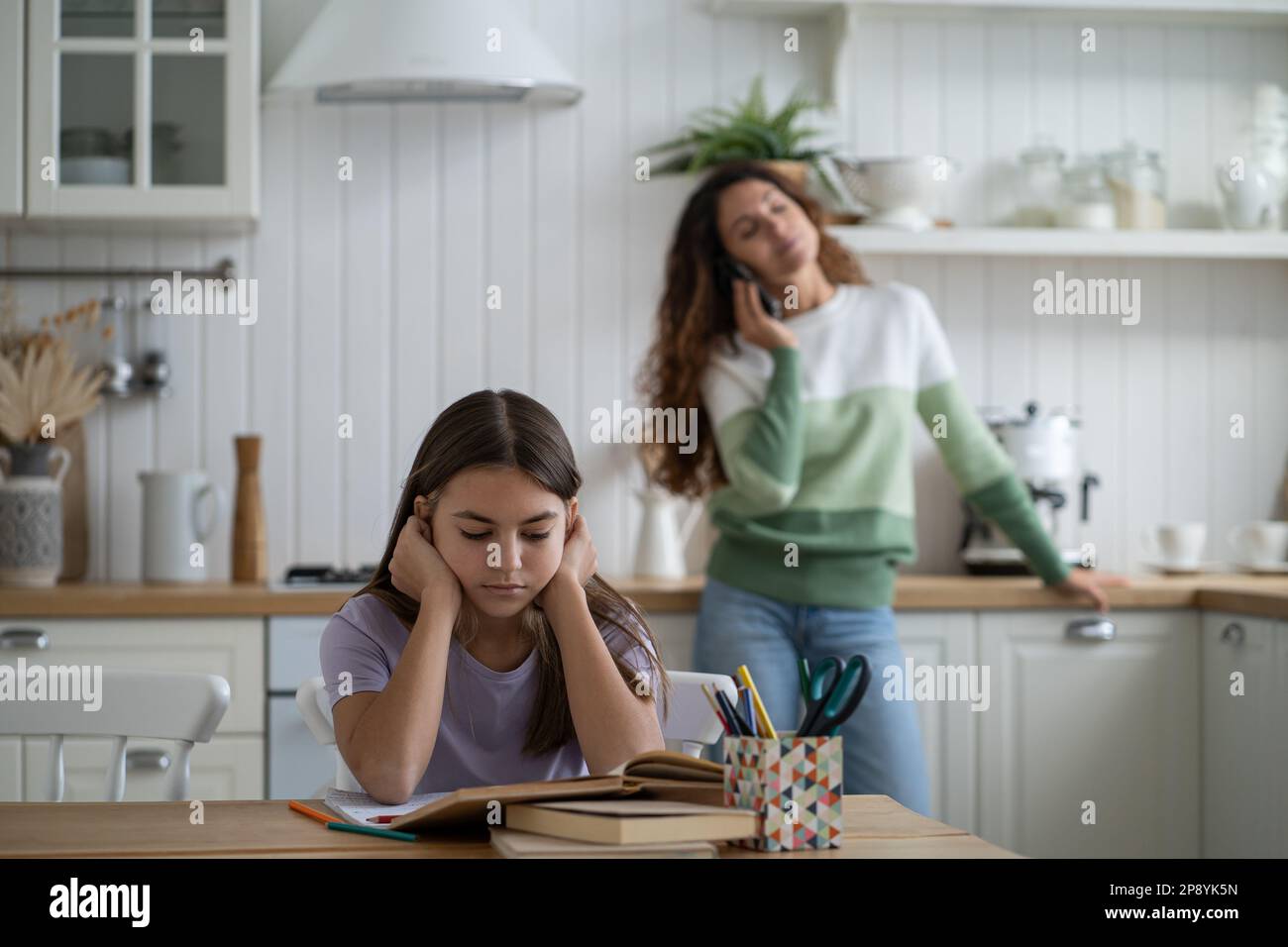 La ragazza teen concentrata che legge i libri che preparano il rapporto o il saggio per la scuola siede al tavolo Foto Stock