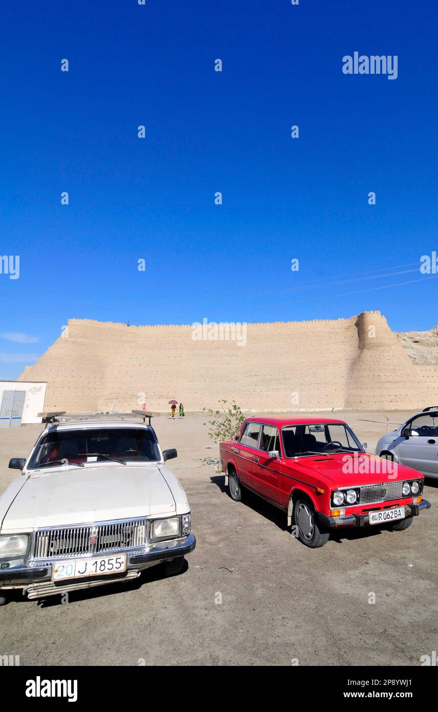 Vecchie auto sovietiche parcheggiate fuori l'Arca di Bukhara, Uzbekistan. Foto Stock