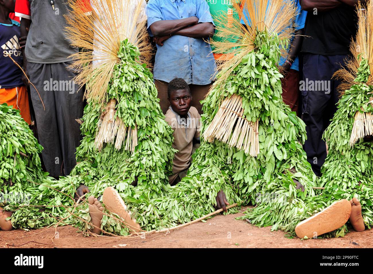 Giovane ragazzo africano seduto con maschere a foglia al Festival di stima a Dedougou, Burkina Faso Foto Stock