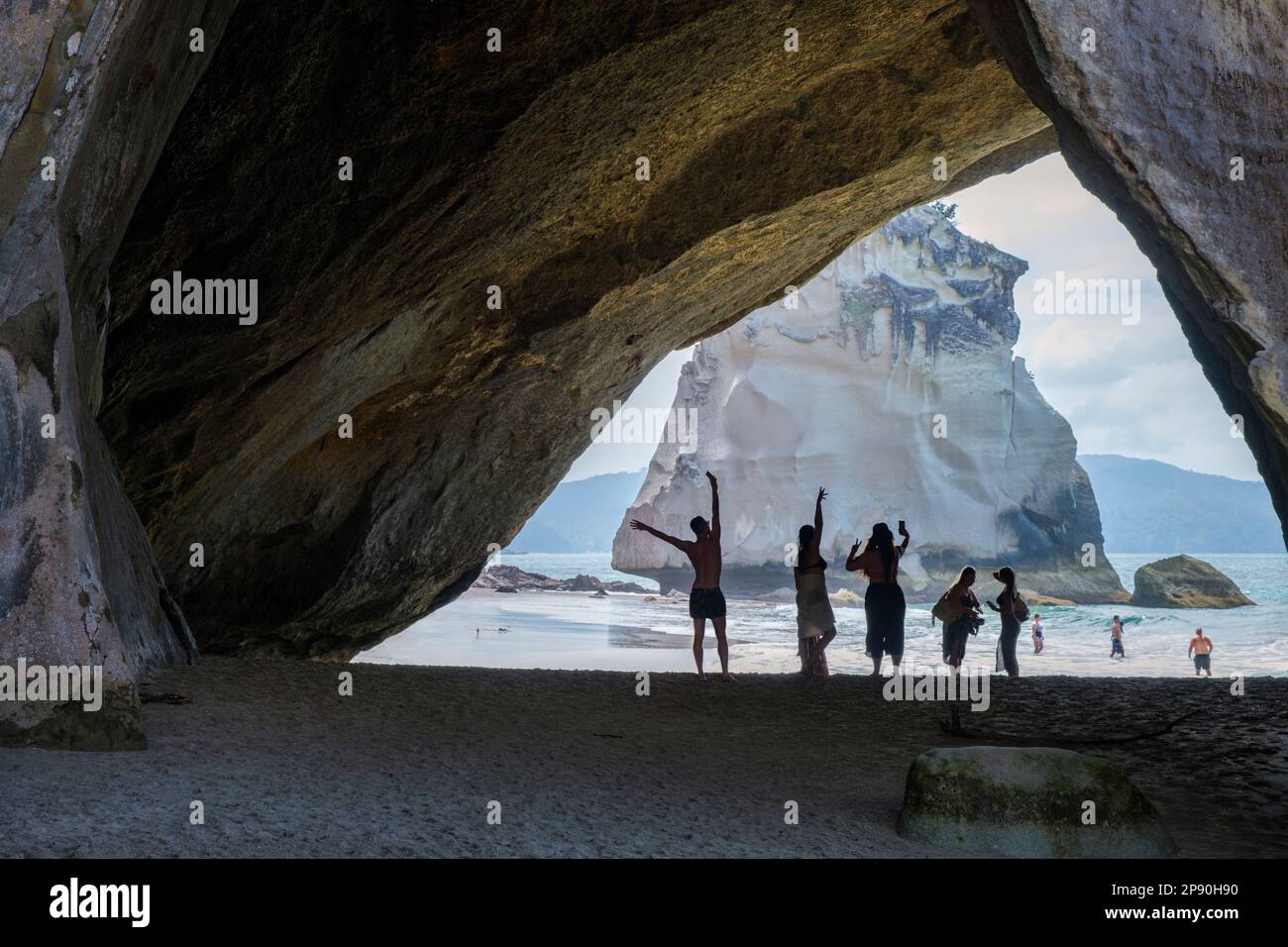 Turisti in posa per fotografie a Cathedral Cove, Coromandel Peninsula, North Island, Nuova Zelanda Foto Stock