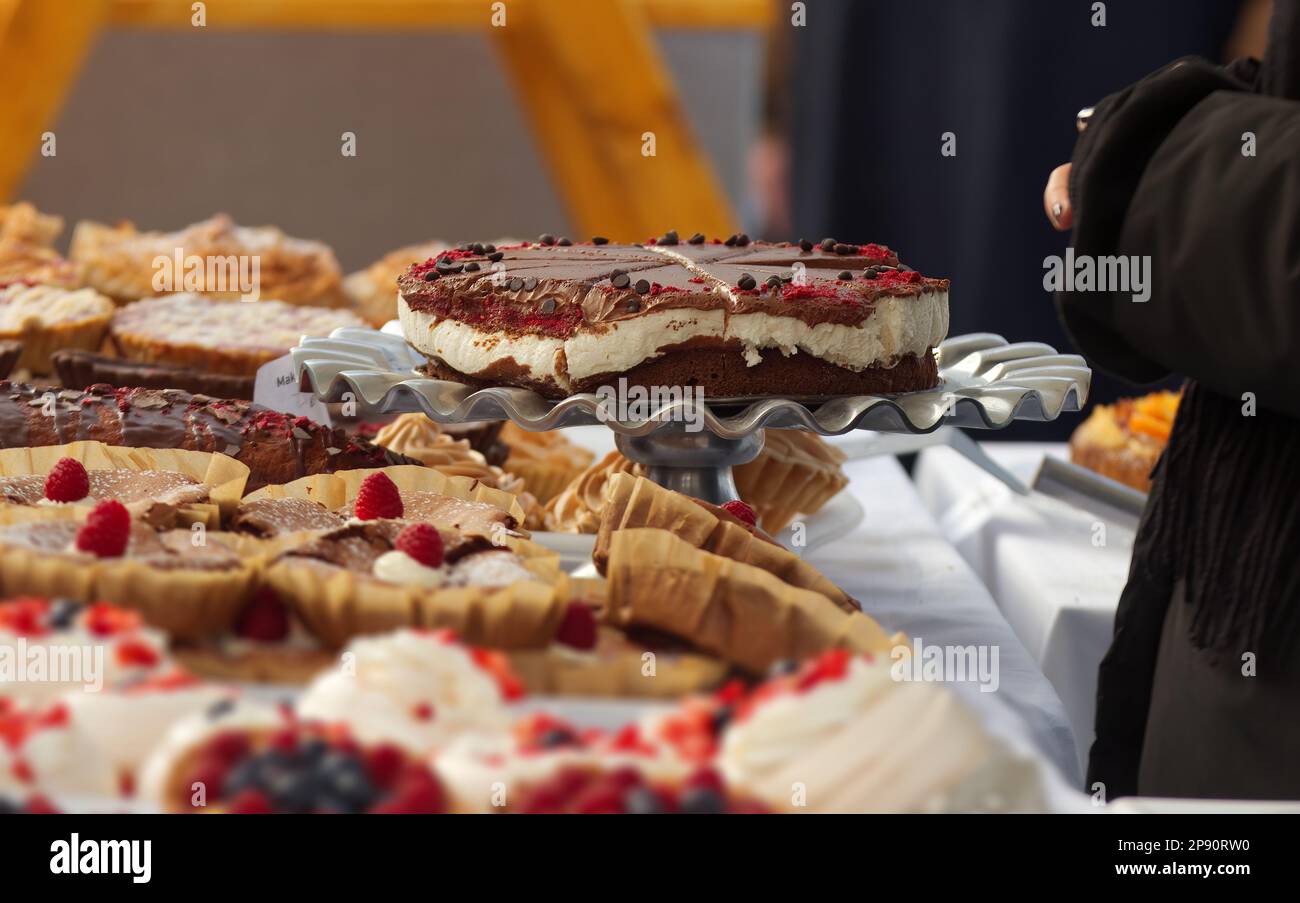 Cheesecake esposto su uno stand tra gli altri dessert presso lo stand dolciario presso il mercato agricolo Street food. Messa a fuoco selettiva, nessuna intelligenza artificiale. Foto Stock