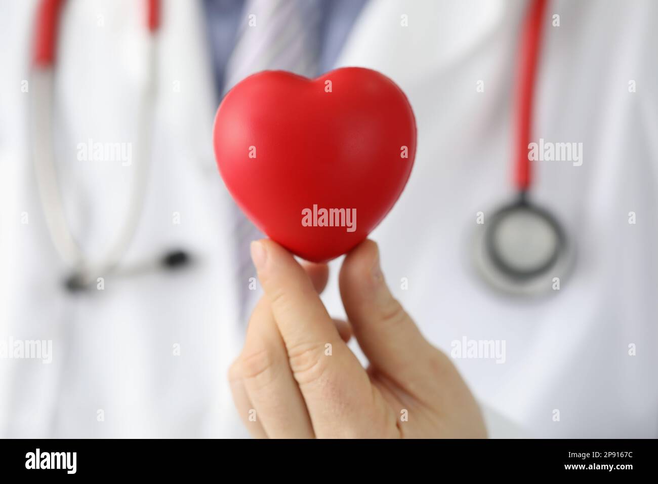 Cardiologo uomo che tiene rosso giocattolo cuore primo piano Foto Stock