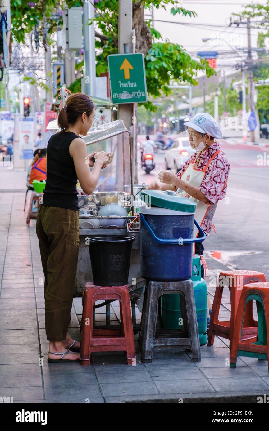 Bangkok Ratchawat Thailandia persone preparare cibo di strada tailandese in una bancarella con un wok padella soffriggere. Foto Stock