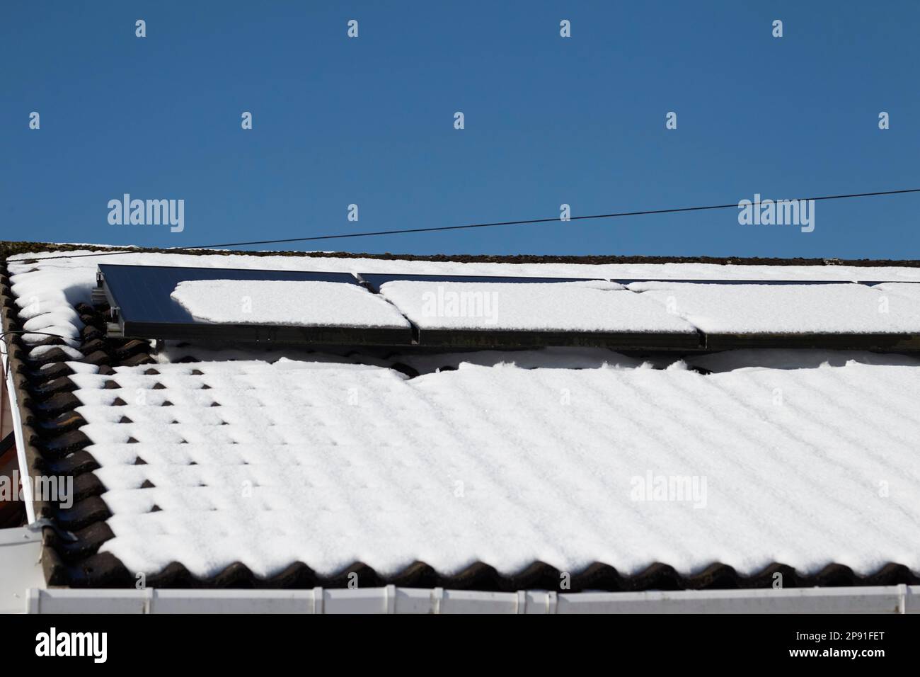 neve che si scioglie su pannelli solari su una casa dopo forte nevicata in inverno newtownabbey irlanda del nord regno unito 10th marzo 2023 Foto Stock
