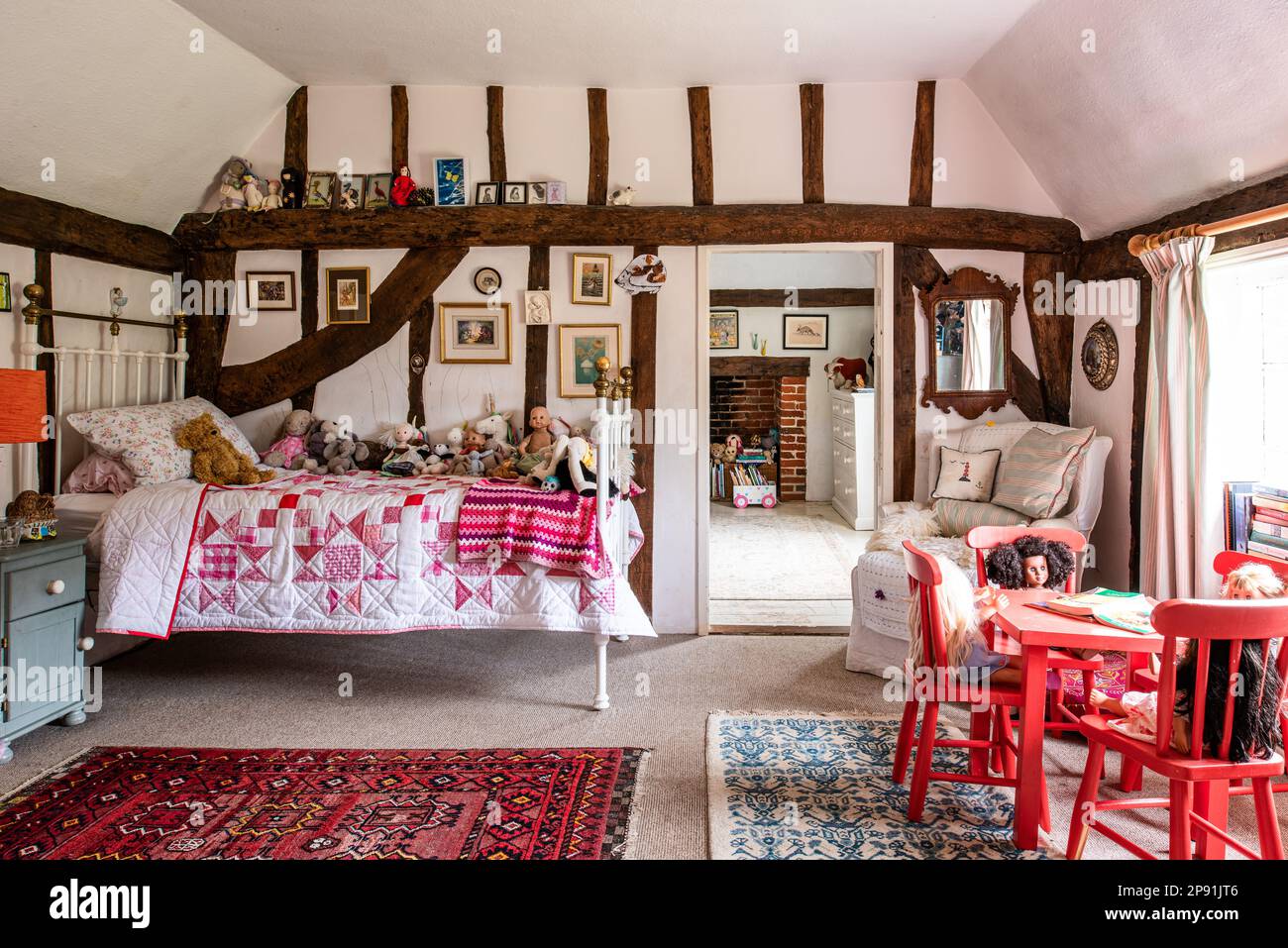 Trapunta patchwork sul letto con giocattoli in legno incorniciato camera da letto della ragazza. 16th ° secolo Tudor casa colonica, Suffolk, Regno Unito. Foto Stock