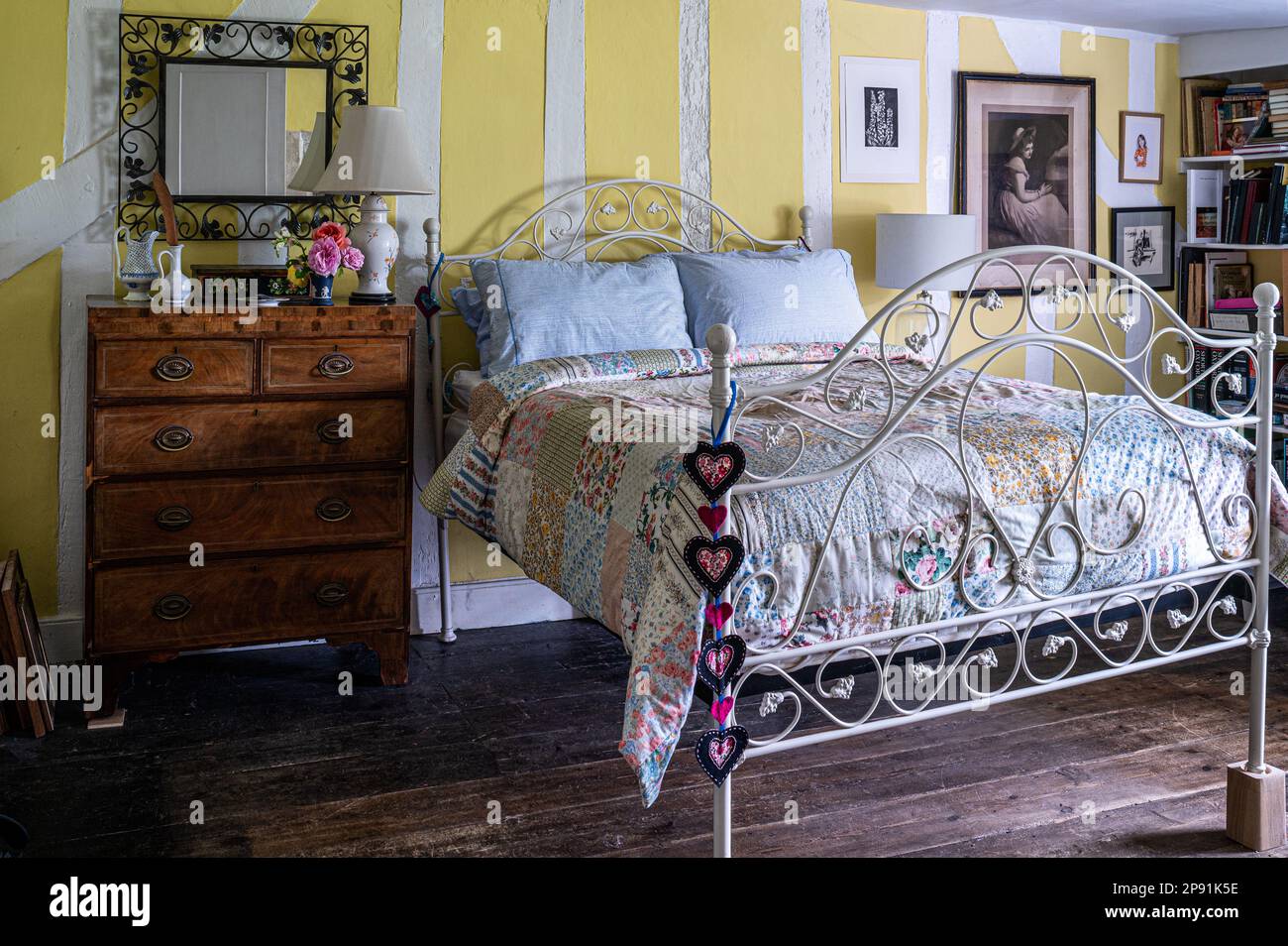 Cuori ricamati e patchwork trapunta in legno incorniciato bedroo del 16th ° secolo Tudor fattoria, Suffolk, Regno Unito. Foto Stock