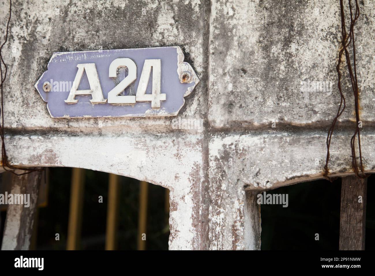 Il vecchio numero di casa una piastra 24 su un molto squallido vecchio muro. Numero della placca. Edificio simbolo del numero Foto Stock