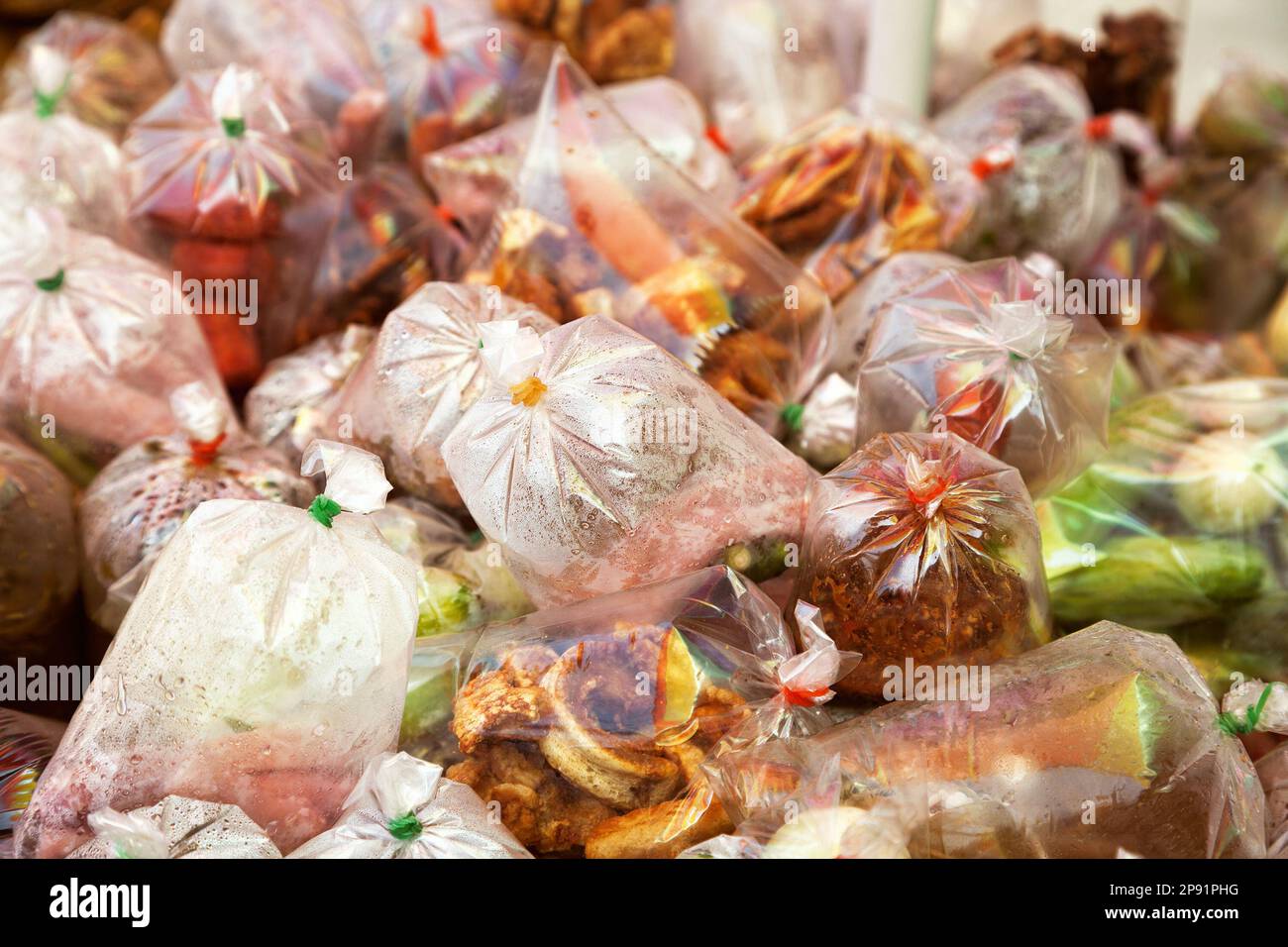 Street food cart con Asiatici esotici cibo da asporto in sacchetti di plastica. All'aperto il fornitore di cibo in stallo su un marciapiede Foto Stock