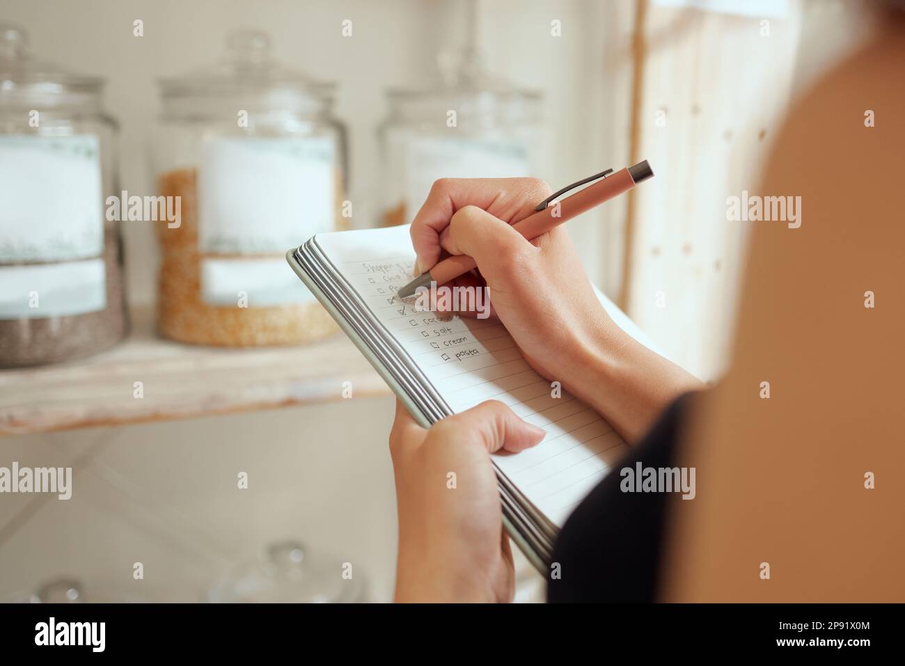 Imprenditore conteggio di stock e scrittura o la lista di acquisto di pianificazione in un negozio su un blocco note. Proprietario di piccola impresa che fa un preventivo per l'inventario e. Foto Stock