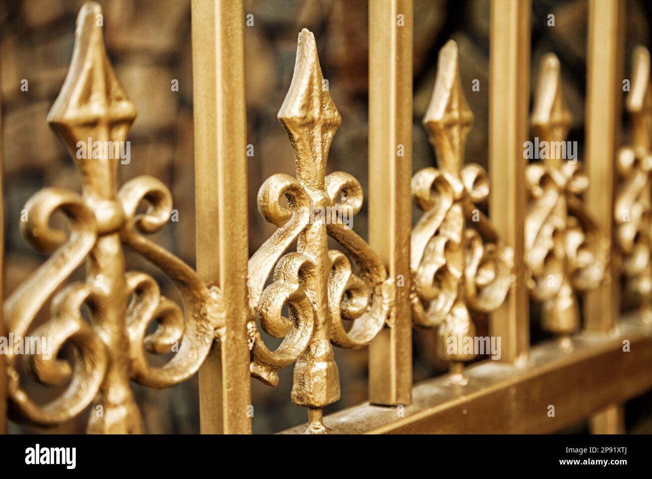 Oro nuovo recinto battuto close-up dello sfondo. Forgiato ornati pattern bello golden barre di sicurezza Foto Stock