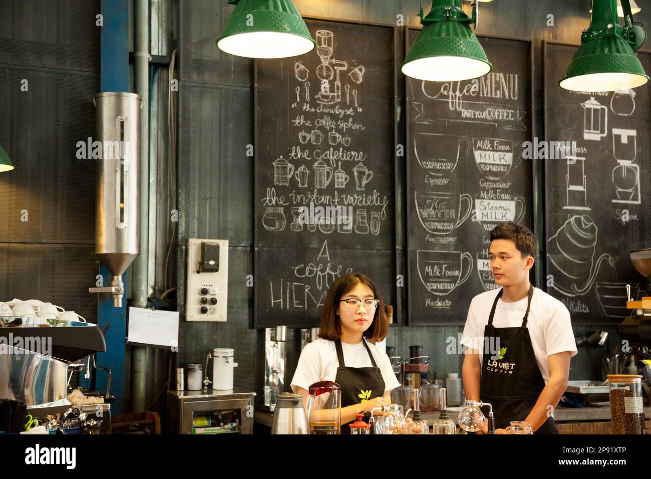 Da Lat, Vietnam - Aprile 3, 2018: due baristi lavorando a un hipster coffee shop. Giovani asiatici di persone a lavorare in un moderno loft cafe Foto Stock