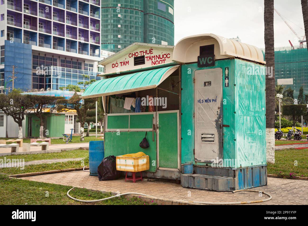 bagno esterno e cabina doccia in plastica in spiaggia. L'esterno di una cabina WC a buon mercato è brutto e si trova in una strada cittadina. Porta-vasino in una città asiatica. Testo: Doccia e nuoto Foto Stock