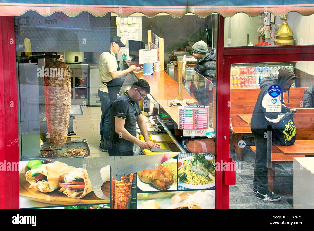 all'interno del kebab pizza take away fast food locale vista da una strada pubblica attraverso la finestra Foto Stock