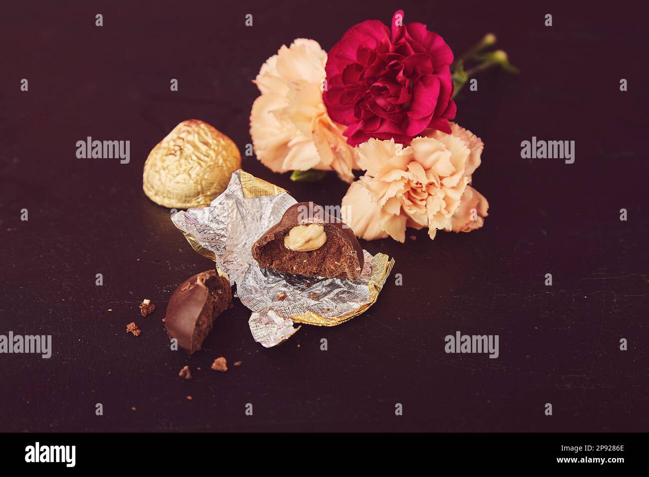 Cioccolato bar - caramelle di noci con fiori estetica. Hygge a casa. Foto Stock