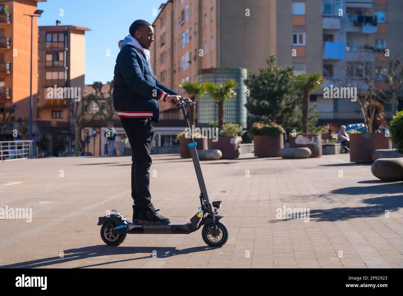 Skateboard maschile etnico nero su uno skateboard elettrico, concetto di nuova mobilità Foto Stock