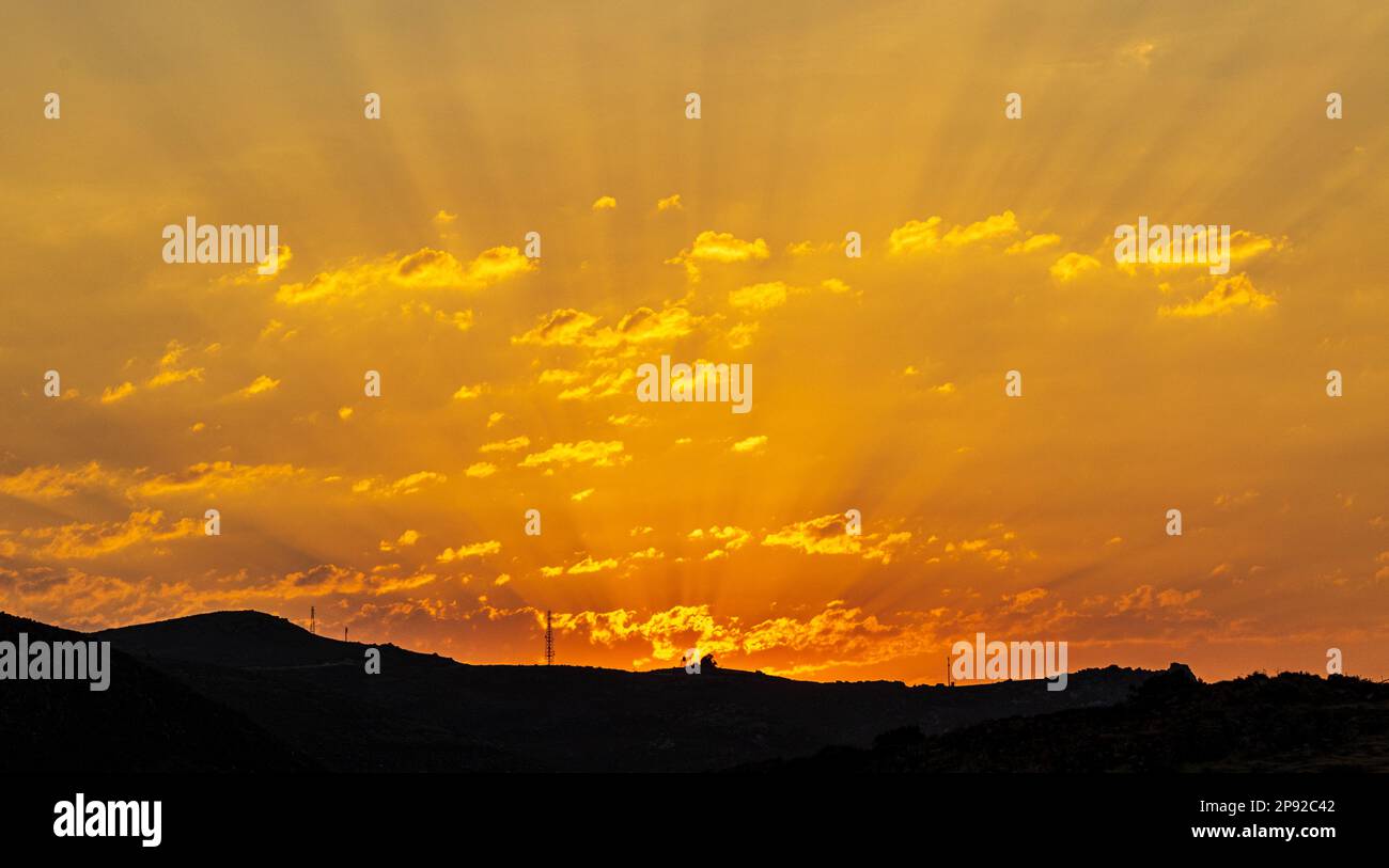 raggi solari che si irradiano al tramonto Foto Stock