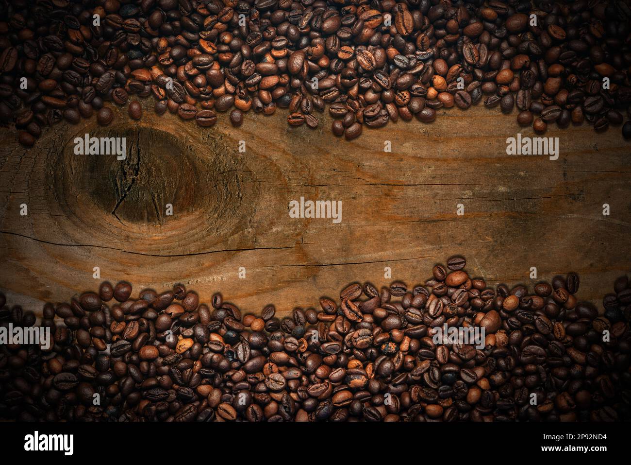 Cornice di chicchi di caffè arrostiti su uno sfondo di legno annodato con spazio copia, fotografia. Foto Stock