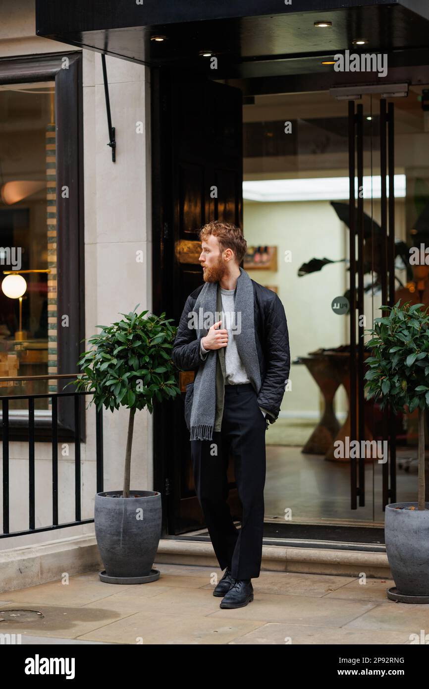 Ritratto di un uomo bearded elegantemente vestito sulla strada Foto Stock