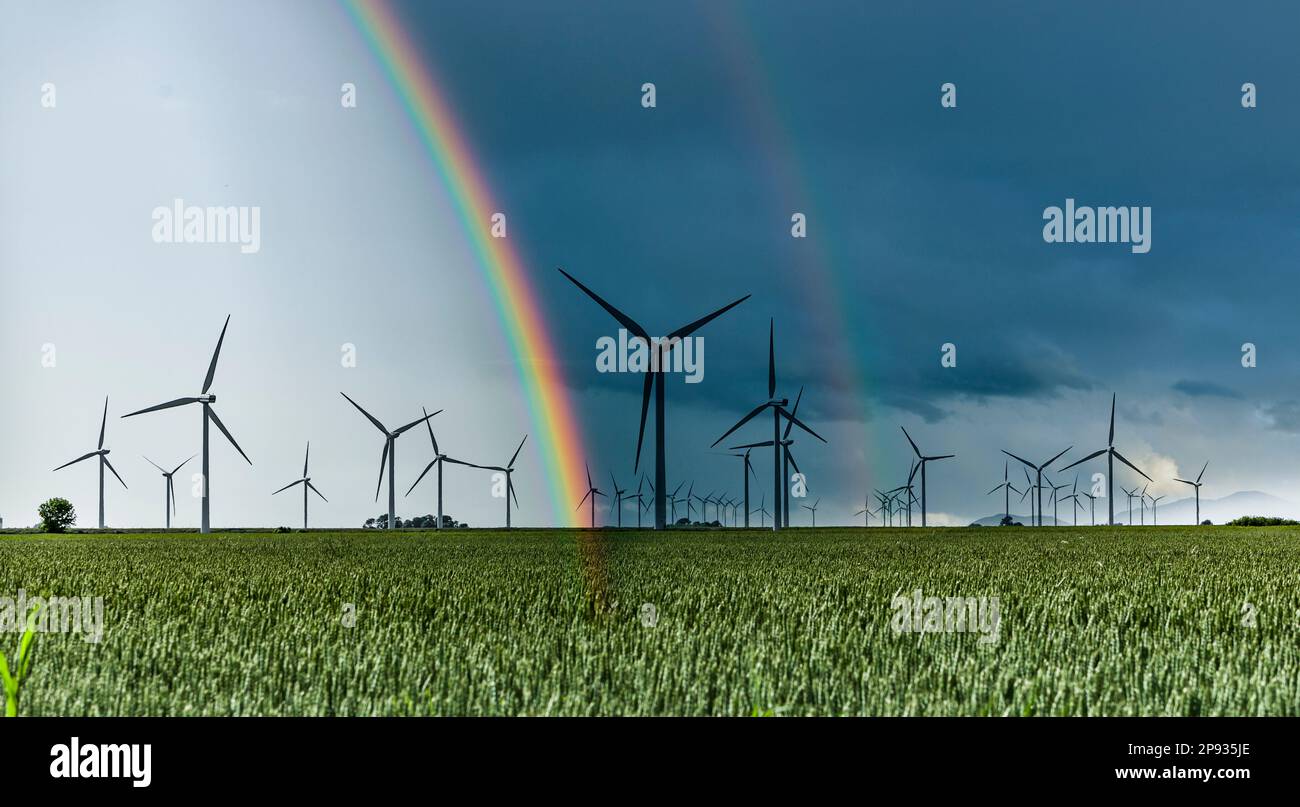 Turbine eoliche in un paesaggio con arcobaleno Foto Stock