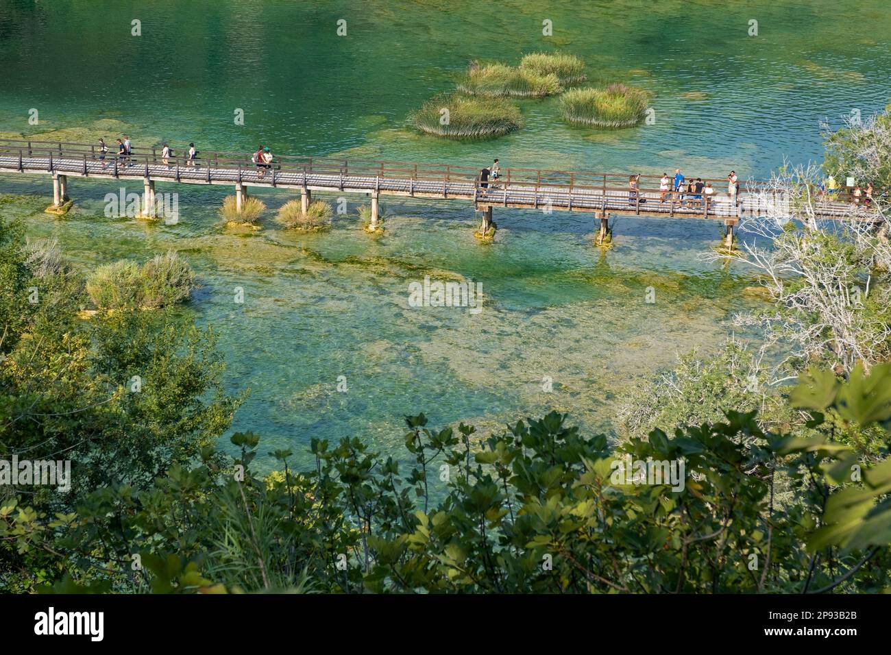 I turisti che camminano sul ponte pedonale di legno sullo stagno in Skradinski buk presso il Parco Nazionale Krka vicino a Šibenik, Dalmazia centrale, Šibenik-Knin, Croazia Foto Stock