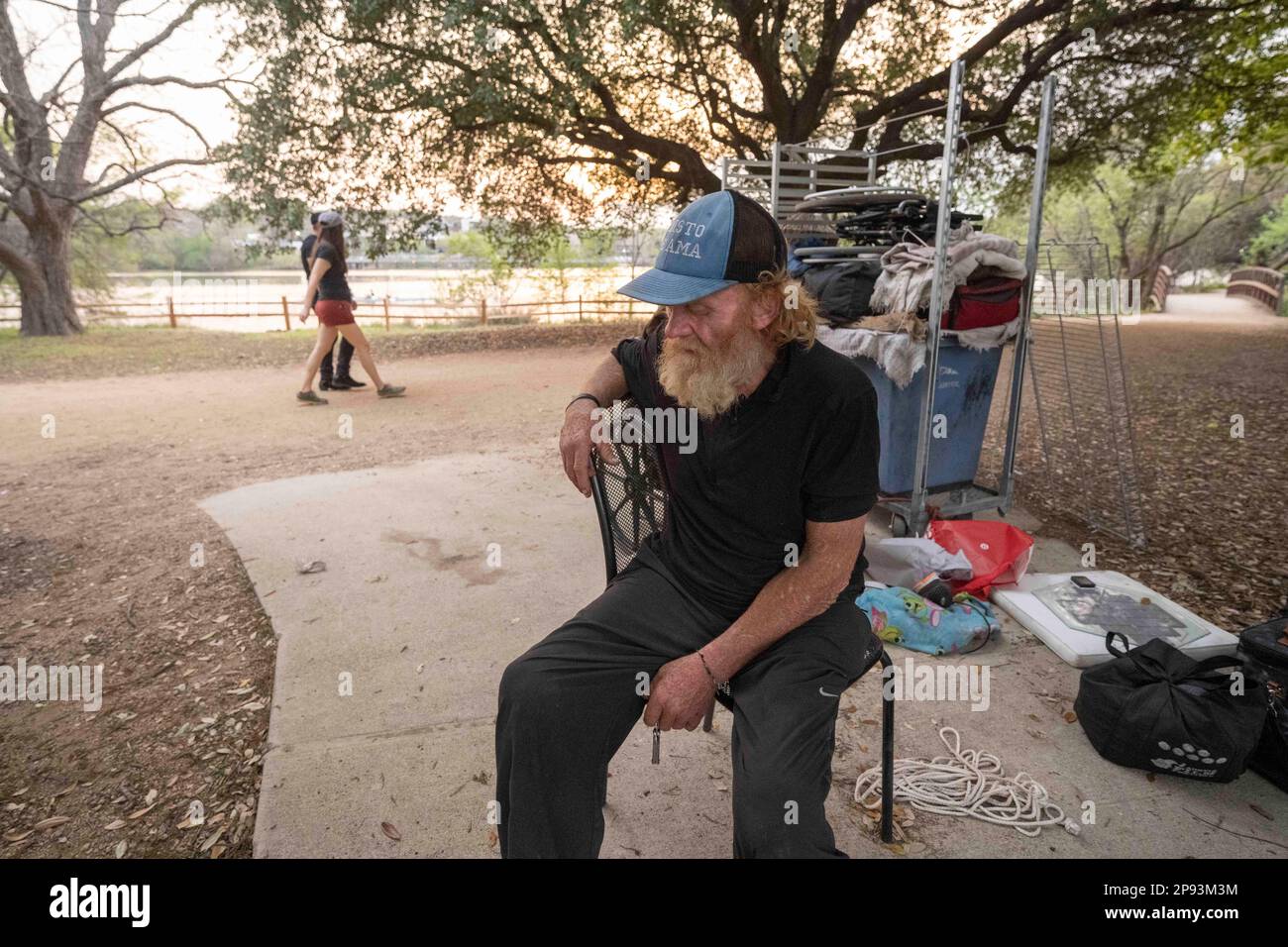 Un uomo senza casa, che desiderava non essere identificato, siede con la maggior parte dei suoi effetti personali al percorso di escursione e bicicletta lungo la riva nord del lago Lady Bird nel centro di Austin il 9 marzo 2023. L'uomo, che si è accampato lungo la costa per circa 9 mesi, è stato infine chiesto di lasciare da equipaggi costruendo una barriera a doppia rotaia e aggiungendo l'illuminazione a seguito di una recente morte annegata nel lago. ©Bob Daemmrich Foto Stock