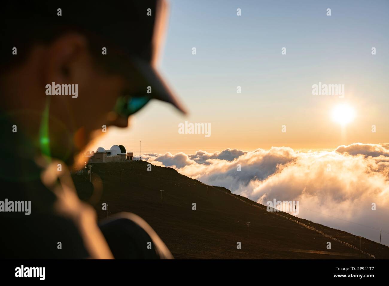 Tramonto sulla cima di Haleakala con testa di uomo sfocata in primo piano, Parco Nazionale di Haleakala, Maui, Hawaii, USA, Polinesia, Oceania Foto Stock