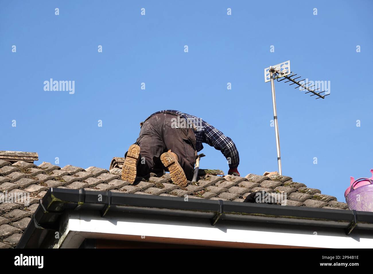 Un tetto che ripara tegole di colmo sul tetto di una casa domestica Foto Stock