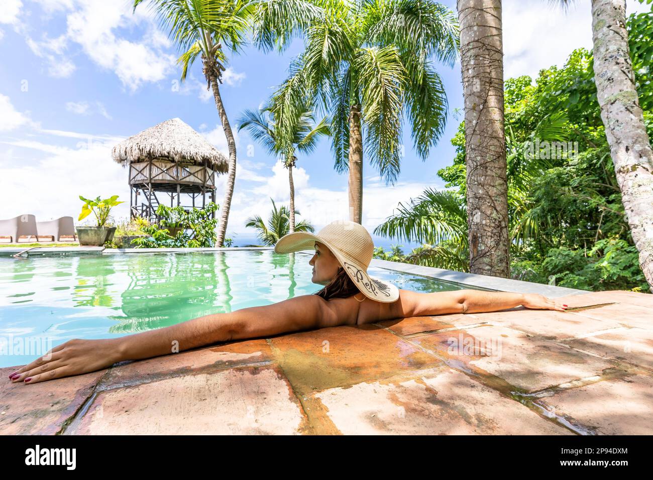 Nord America, Caraibi, grandi Antille, Isola di Hispaniola, Repubblica Dominicana, Sama, Hacienda Cocuyo, bella donna si affaccia a bordo piscina e gode il sole Foto Stock