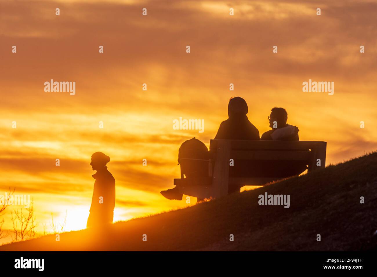 Vienna, tramonto ardente, 2 uomini seduti sulla panchina, persone come silhouette nel 19. Döbling, Vienna, Austria Foto Stock