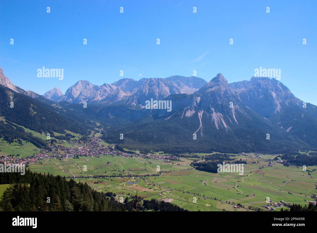 Vista dal Tuftlalm (1496m m) a Ehrwald e alla catena montuosa Mieminger, con le prominenti Sonnenspitze (2417m m), Lermoos, Zugspitzarena, Tirolo, Austria Foto Stock