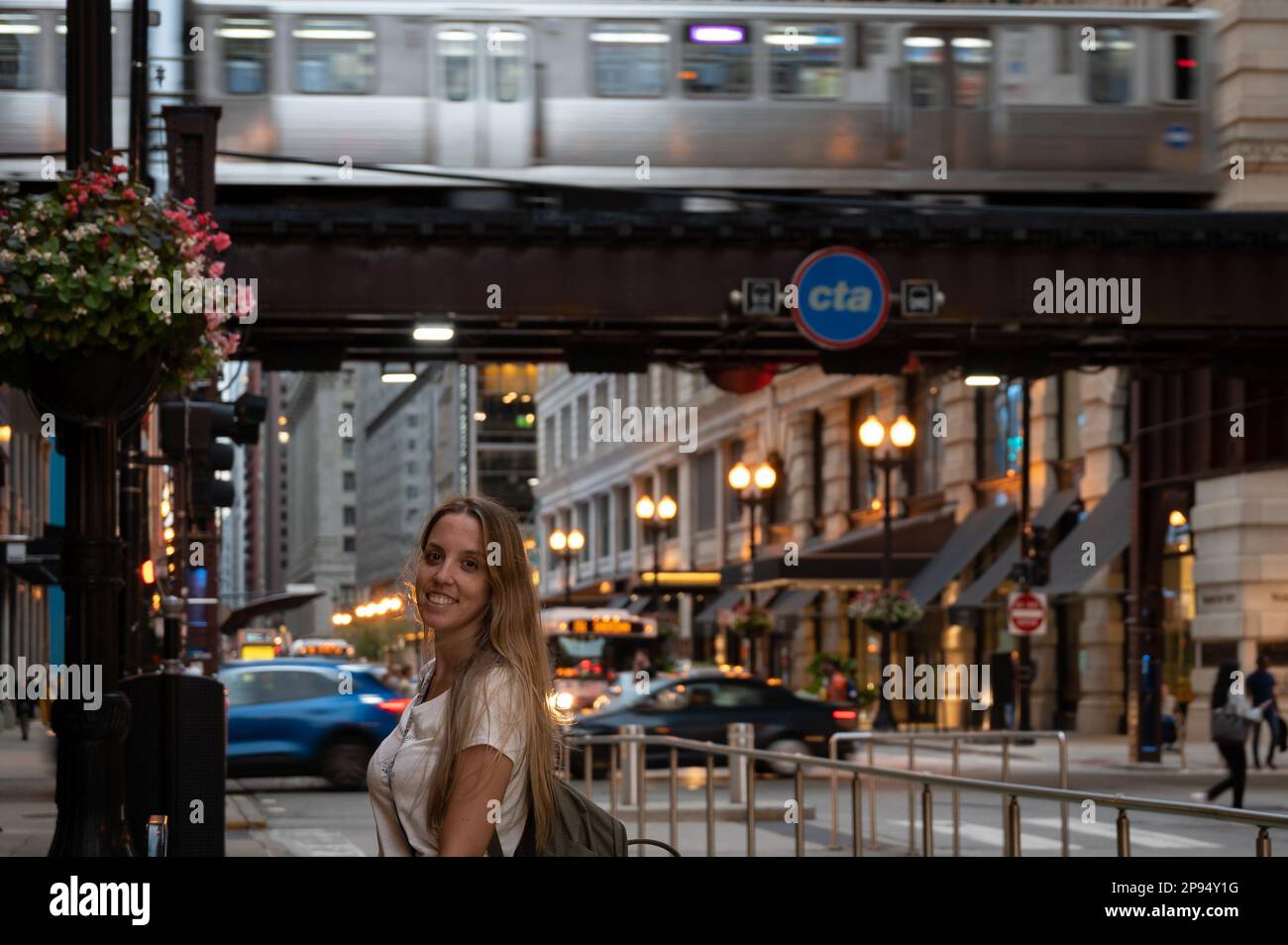 Giovane ragazza bionda con zaino e macchina fotografica in vacanza estiva a Chicago al tramonto Foto Stock