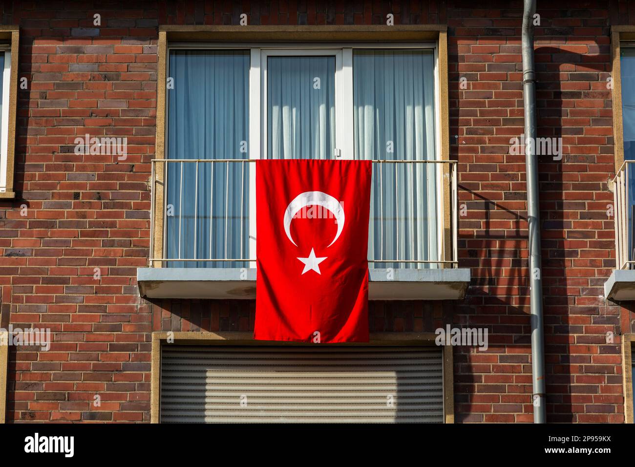 Bandiera nazionale della Turchia sulla facciata di una casa a Oberhausen nella regione della Ruhr come simbolo di solidarietà e solidarietà con le vittime del terremoto in Turchia e Siria dal 06.02.2023 Foto Stock