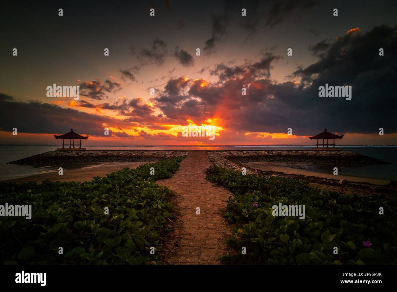 Alba sulla spiaggia di Sanur a Bali, tempio / pagoda in mare come un frangiflutti, romantico ambiente con riflessione in acqua. Foto Stock