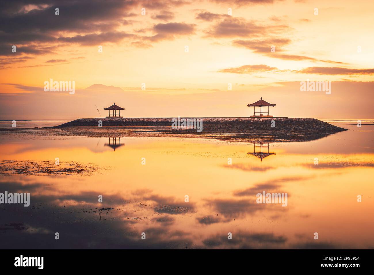 Alba sulla spiaggia di Sanur a Bali, tempio / pagoda in mare come un frangiflutti, romantico ambiente con riflessione in acqua. Foto Stock