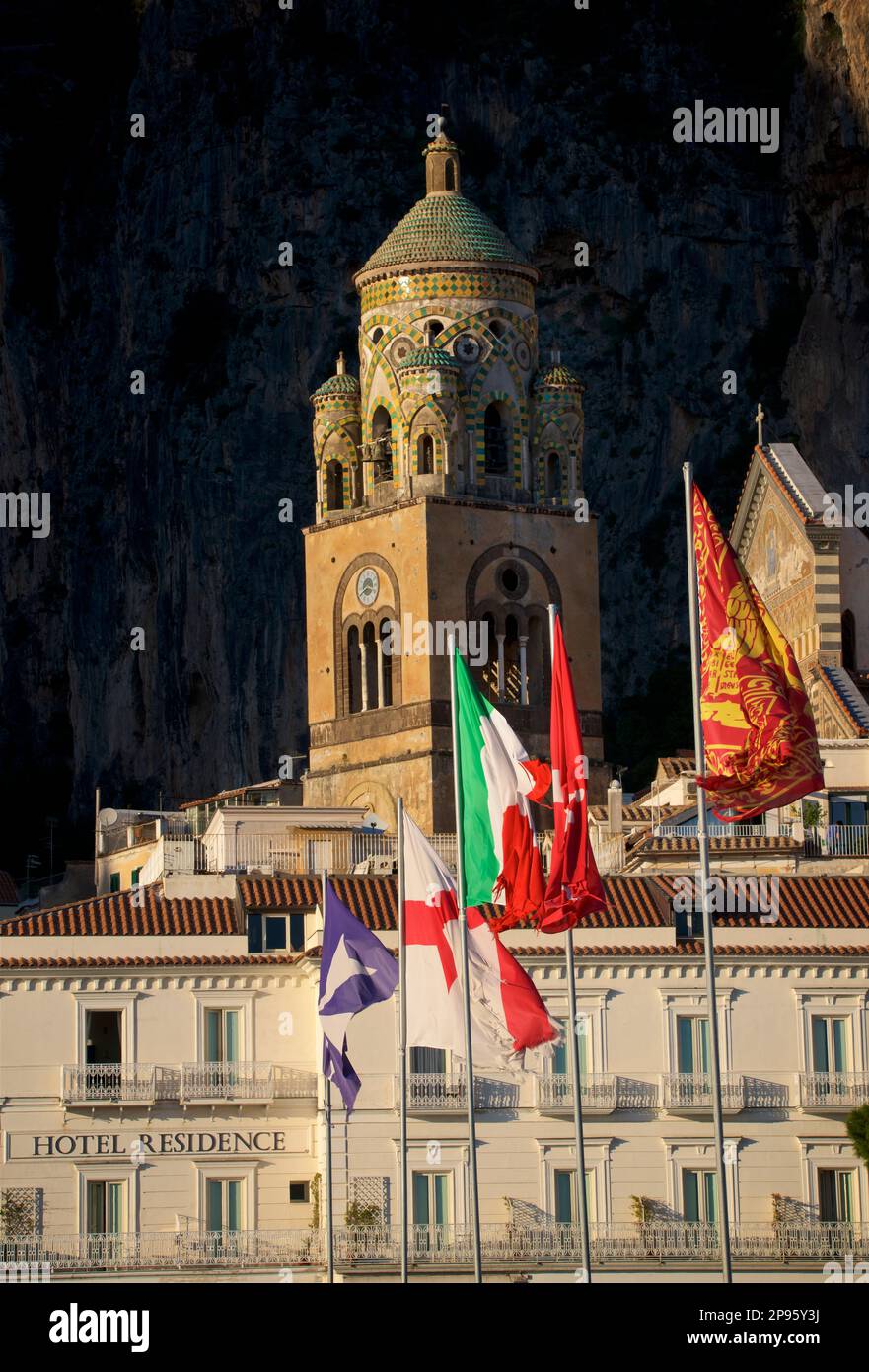 Bandiere sul molo e sul Campanile del Duomo di Sant'Andrea. Amalfi, Salerno, Italia Costiera Amalfitana. Iniziata nei secoli 9th e 10th, la cattedrale è stata aggiunta e ridecorata più volte, sovrapponendo elementi arabo-normanni, gotici, rinascimentali, barocchi, E infine una nuova facciata Normanno-Arabo-Bizantina del 19th° secolo. Bandiere multiple sui flagpoli che soffiano nel vento Foto Stock