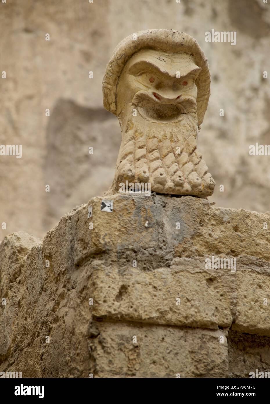 Ercolano scoperto. Ercolano fu sepolta sotto cenere vulcanica e pomice nell'eruzione del Vesuvio nel 79 d.C. Ercolano, Campania, Italia . Testa intagliata / modellata su un muro in Casa numero 22. Maschera teatrale in marmo. Casa del Mosaico Nettuno Foto Stock