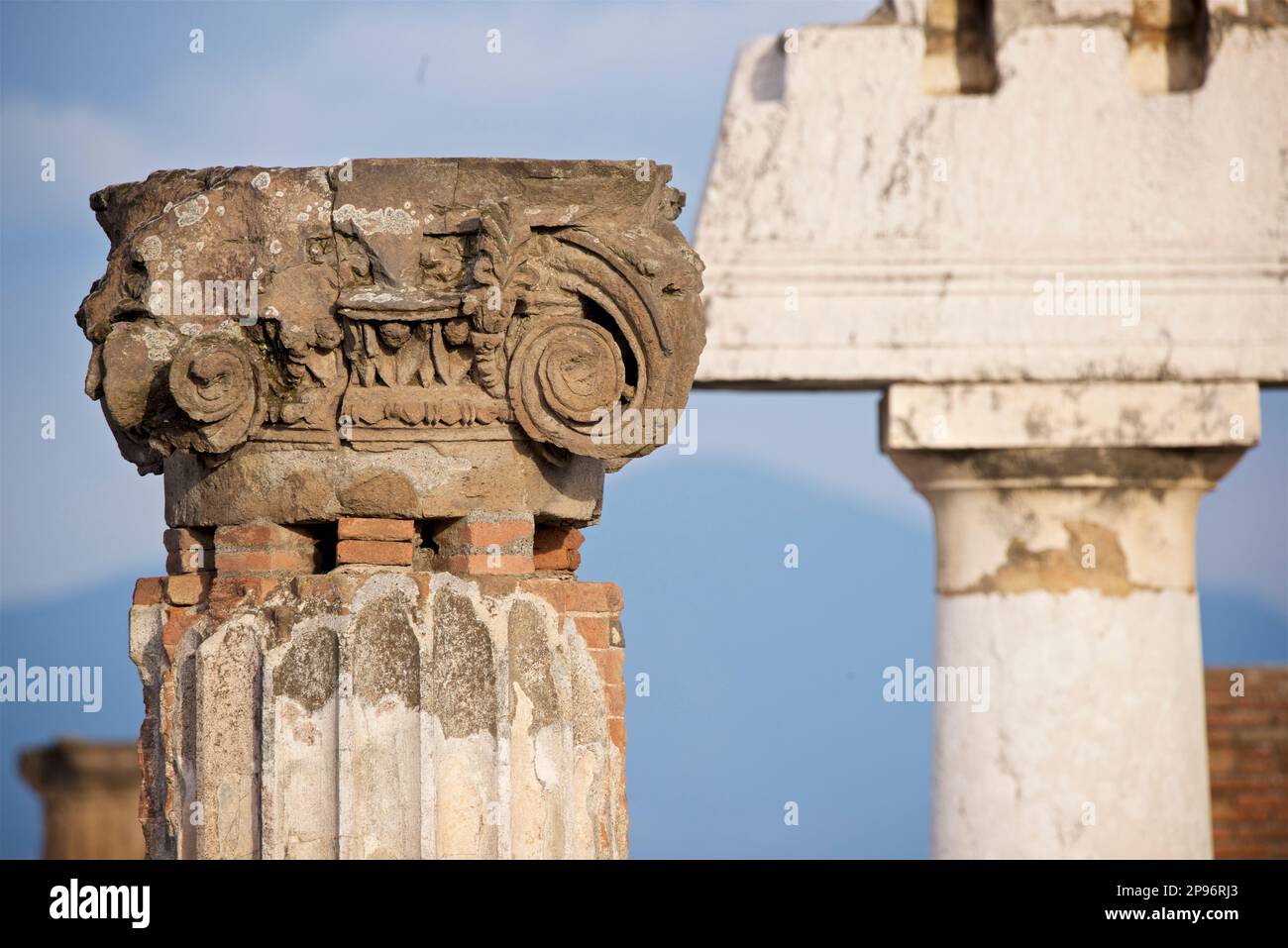 Particolare di una colonna di pietra scanalata e della rotta capitale ionica con volute a Pompei, Napoli, Italia Foto Stock