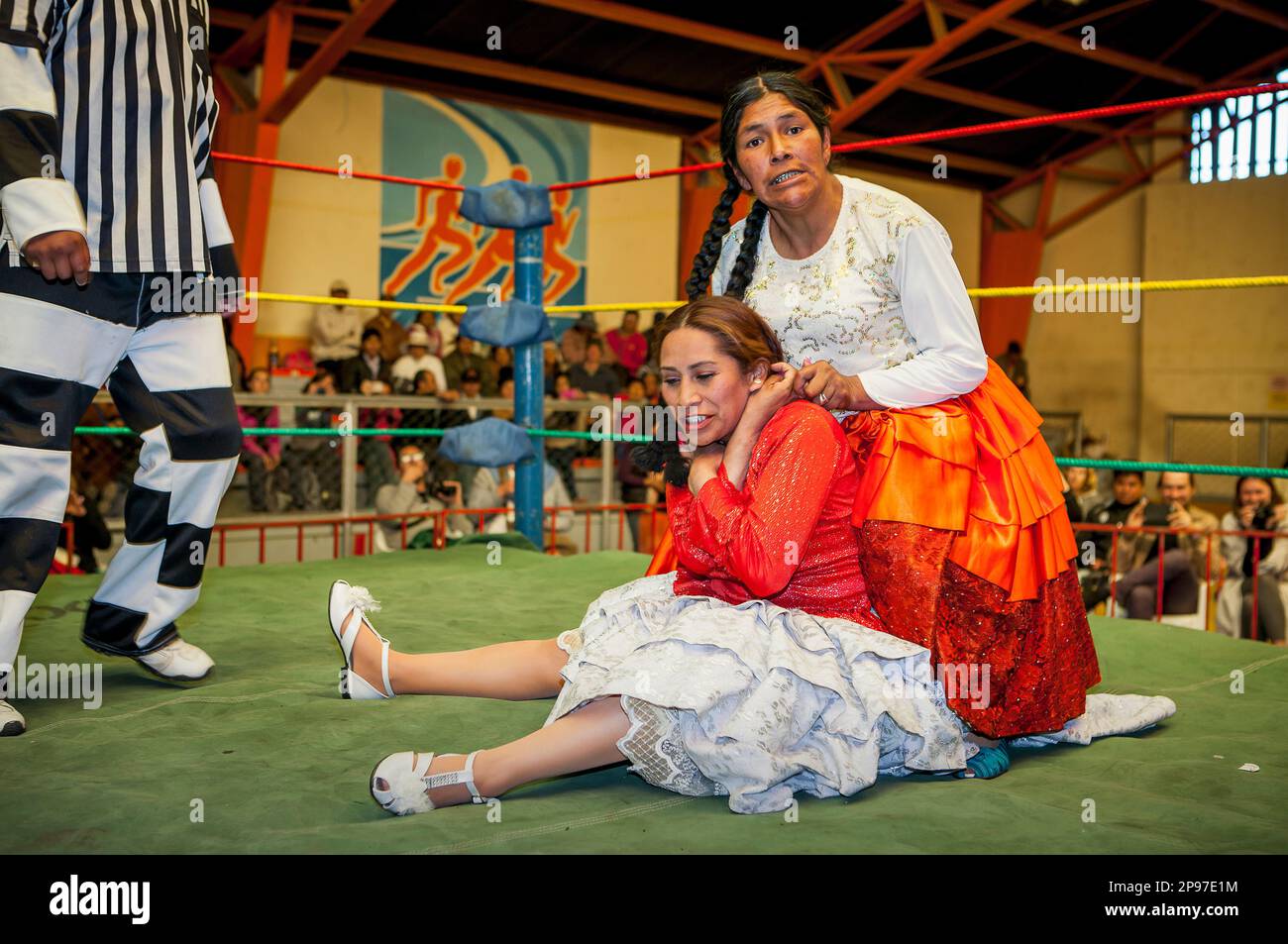 Lucha Libre. Combattimento tra Dina con gonna arancione e Benita la Intocable , lottatori di donne cholitas , con arbitro, centro sportivo la Ceja, El Alto, Foto Stock