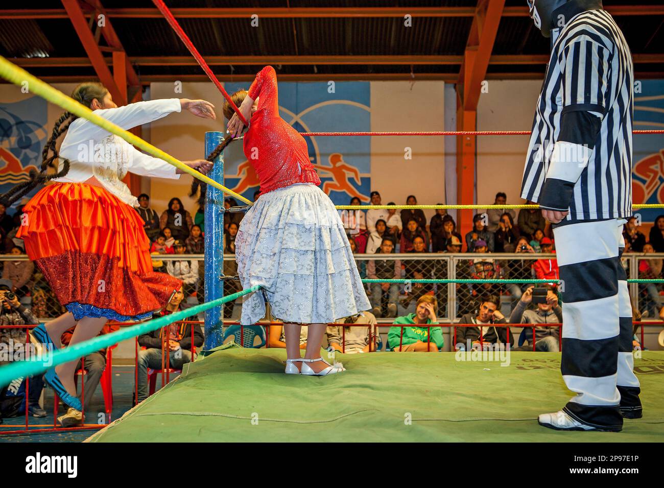 Lucha Libre. Combattimento tra Dina con gonna arancione e Benita la Intocable , lottatori di donne cholitas , con arbitro, centro sportivo la Ceja, El Alto, Foto Stock