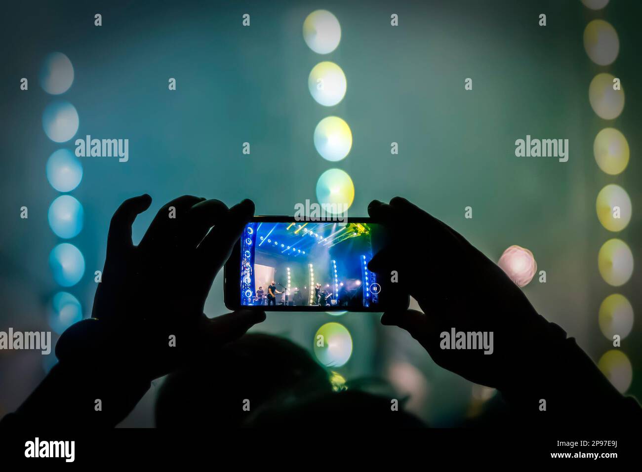 I giovani scattano foto o video di un concerto su smartphone. Foto Stock