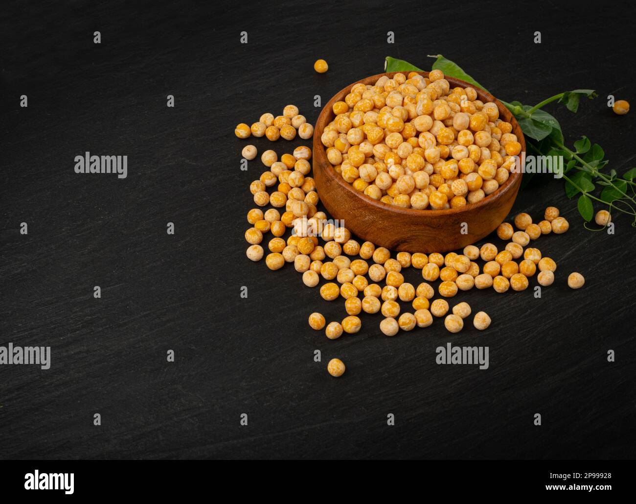 Piselli gialli secchi su fondo nero, pile di piselli interi, legume grezzo, fonte proteica, cibo vegano sano, Piselli gialli secchi sparsi su sfondo bianco Foto Stock