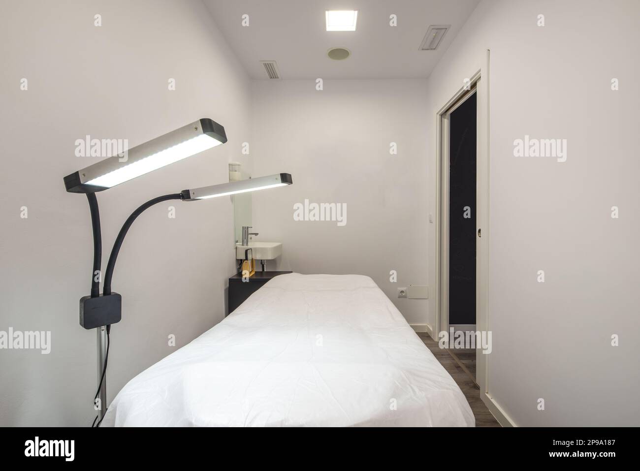 Cabine individuali nella sala massaggi con letti per l'applicazione di trattamenti con potenti lampade a doppio LED Foto Stock