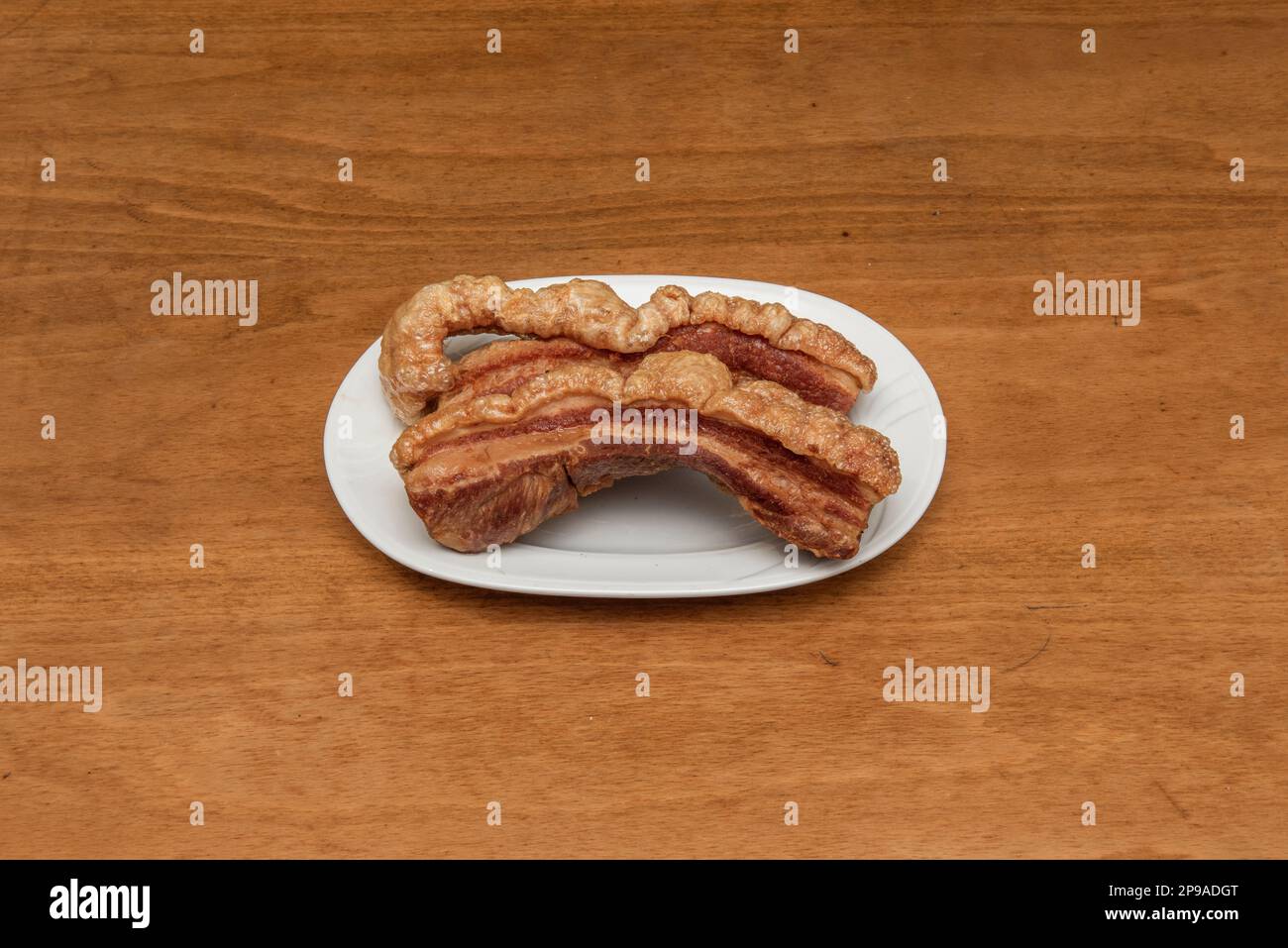 Un torrezno è una striscia di pancetta, sempre con la pelle sopra, fritta o saltata in una padella o tostata sulla griglia. i torreznos sono croccanti e dorati sul Foto Stock