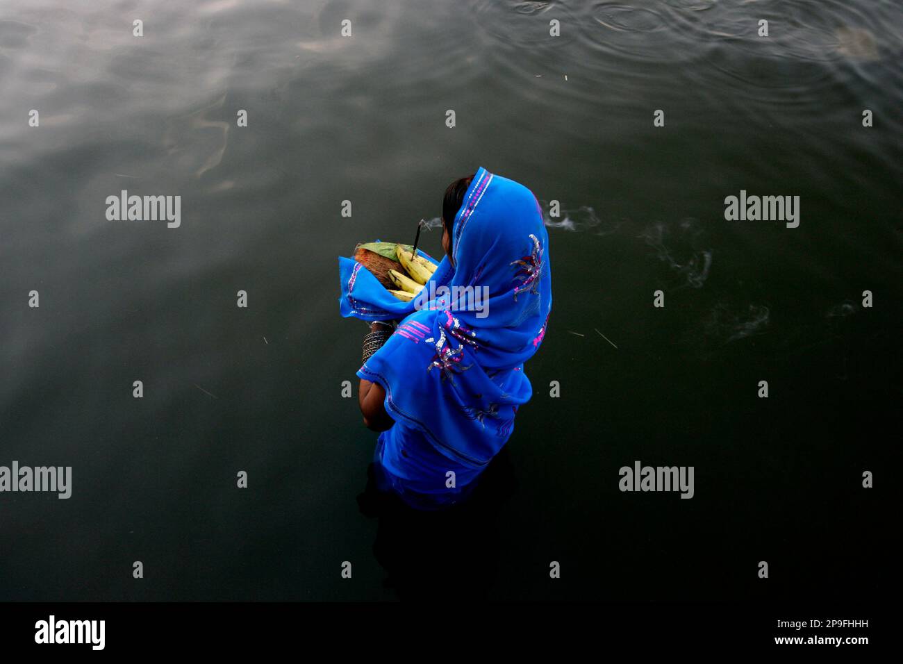 A Hindu woman offers prayers on the occasion of the festival of Chhat, dedicated to the worship of the Sun God, in Amritsar, India, Tuesday, Nov. 4, 2008. (AP Photo/Altaf Qadri) Foto Stock