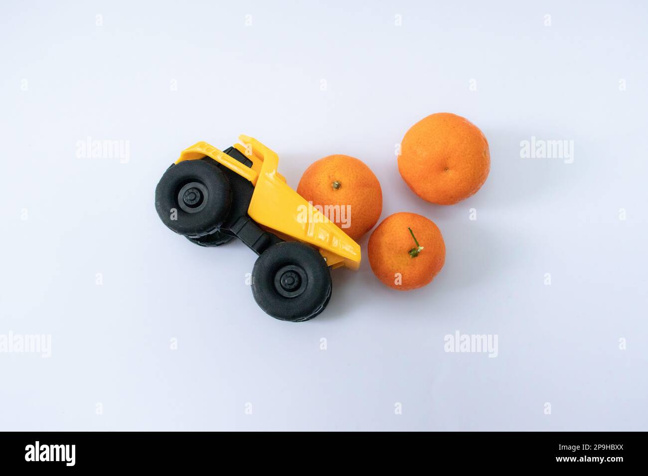 Concetto per non sovraccaricare quando porta roba. Una foto dopo alcune modifiche, un camion giallo porta qualche arance e capovolto. Foto Stock