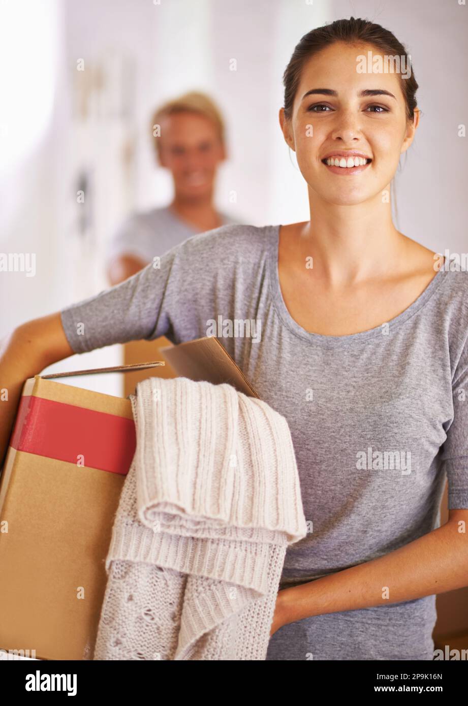 Tutto pronto all'uso. Ritratto di una giovane donna che tiene una scatola nel giorno in movimento. Foto Stock