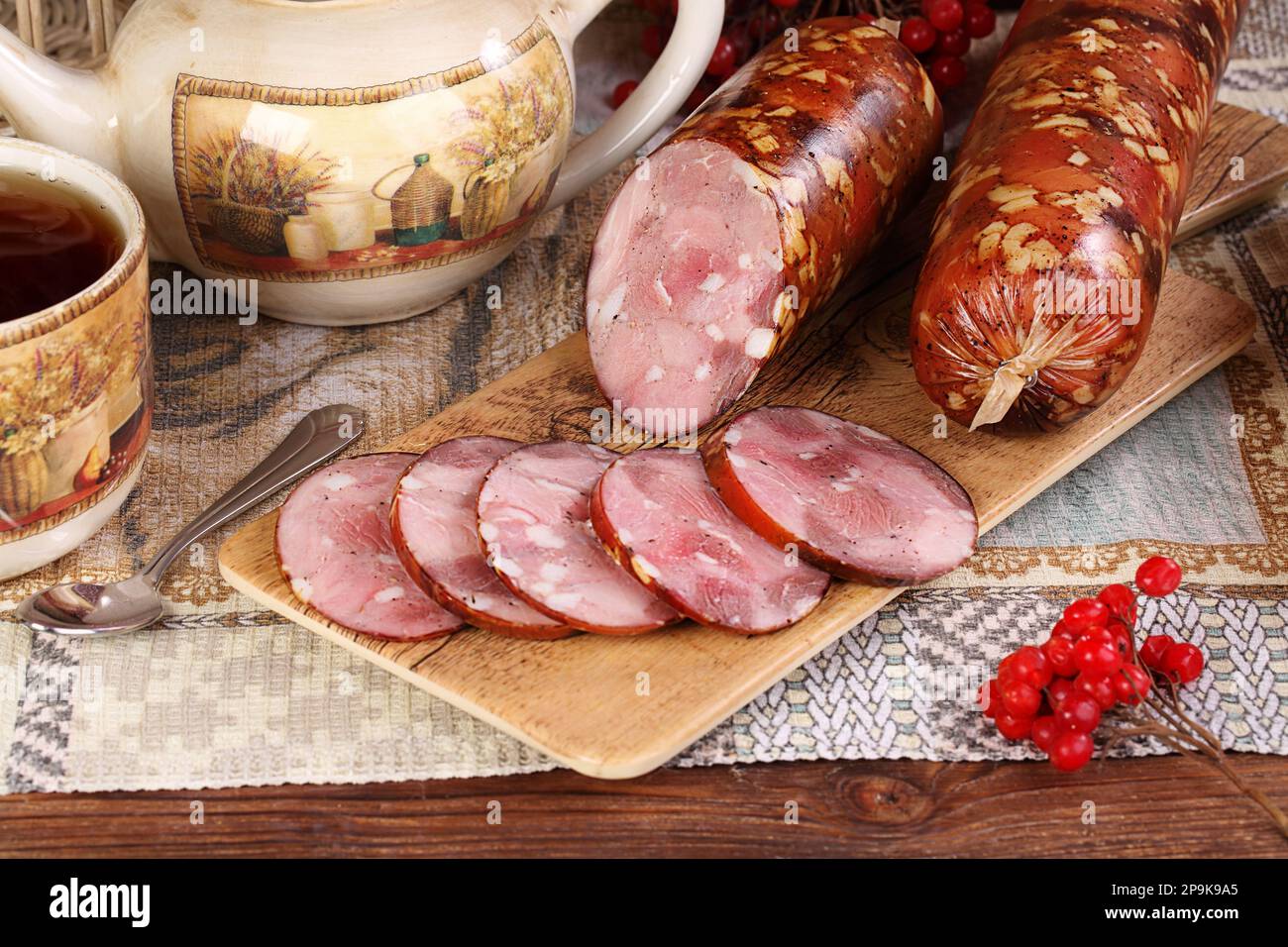 Salsiccia di maiale con tè su sfondo di legno Foto Stock