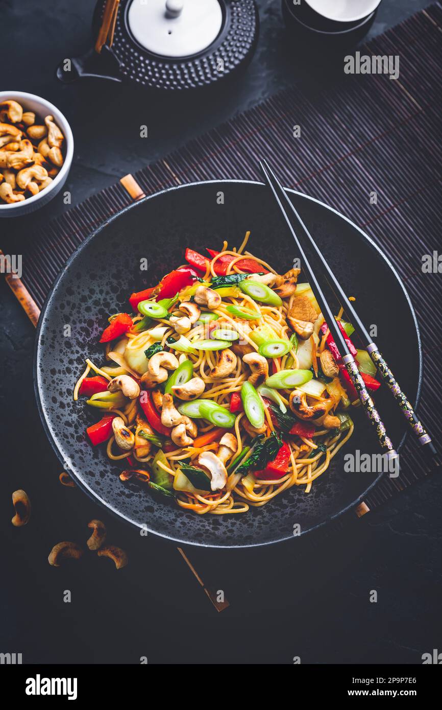 Mescolare gli spaghetti saltati con pollo, verdure e anacardi tostati Foto Stock