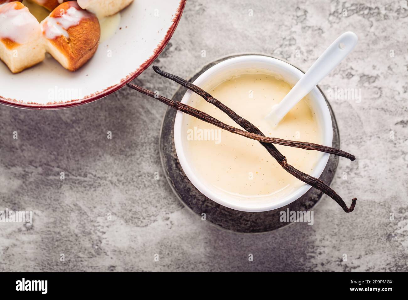 Buchteln, panini dolci a base di lievito con latte e burro, serviti con salsa alla vaniglia. Piatto tradizionale senza carne in Europa Foto Stock